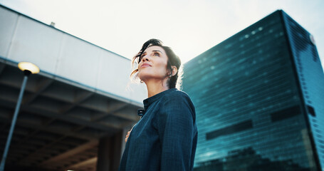 Morning, inspiration and business woman in city with idea, brainstorming and career insights. Thinking, low angle and confident person for company future, urban development and job opportunity © peopleimages.com