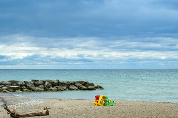 Relax and breath: tranquil beach scene with blue sky and colorful chairs out on the sand Balmy Beach in Toronto shot in March room for text