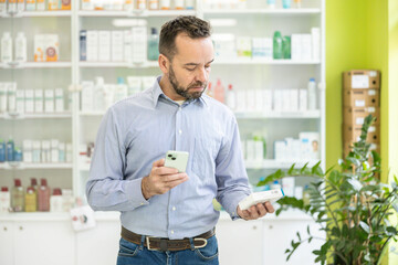 A man compares a medicine box with information on his phone, illustrating the merge of technology...