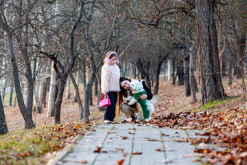 Fototapeta premium Pictures of two little girls while walking and playing with their white-collared dogs, they were the happiest and most joyful. Walking with dogs is one of the healthiest human activities.