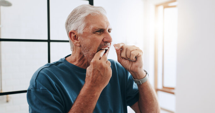 Senior man, flossing and dental health in home, grooming tool and prevention of gum disease. Elderly person, morning routine and oral care with string to remove food, cosmetic thread and fresh mouth