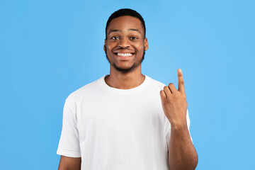 Fototapeta premium African Man Showing Number One Counting On Fingers Smiling To Camera Standing On Blue Background. Studio Shot