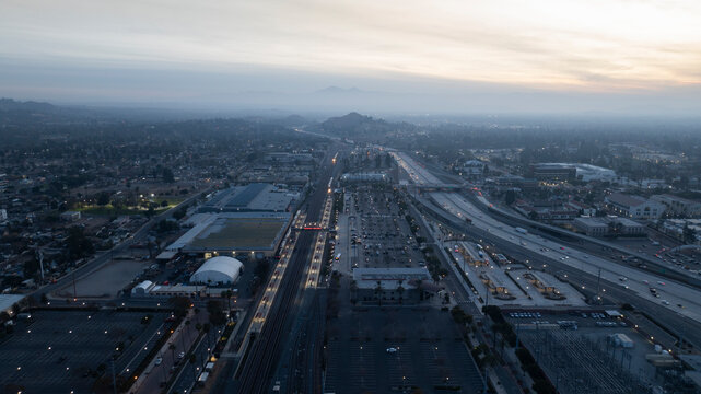 Riverside, California, USA - December 31, 204: A train pulls into the Downtown Train Station and traffic passes on the 91 freeway.