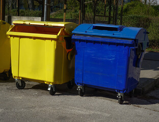 Yellow and blue recycling bins for plastic and paper waste outdoor waste separation and environmental sustainability concept