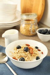 Tasty oatmeal with milk, blueberries and almonds in bowl served on table, closeup