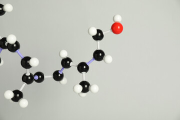 Molecule of retinol (vitamin A) on light grey background, closeup. Chemical model