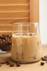Coffee cream liqueur in glass and beans on wooden table