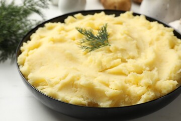Delicious mashed potato with dill served on white table, closeup