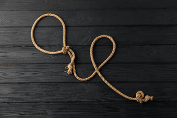 Obraz premium Lasso made of cotton rope on black wooden background, top view
