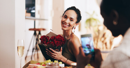 Interracial couple, red roses or valentines day with picture for gift, surprise or social media post at home. Happy woman, man or lovers with phone camera, champagne or flower bouquet for love memory