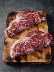 High-quality Raw Marbled Beef Steaks on Rustic Wooden Cutting Board Top View
