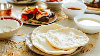 A table set with flatbreads, sauces, and dishes. Flatbreads are the focus, surrounded by various sauces and dishes, creating a vibrant dining scene. Mediterranean food with pita bread.