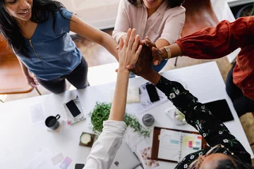 Fototapete Diverse group of women joining hands in teamwork. Teamwork, collaboration, and unity are highlighted. Diverse hands come together as teamwork and business collaboration. Business team building © Rawpixel.com