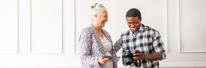 Elderly woman and young man enjoying photography. Smiling woman and man with camera. Happy...