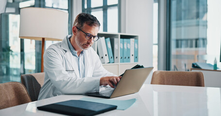 Healthcare, laptop and report with doctor man at desk in office of hospital for diagnosis, planning...