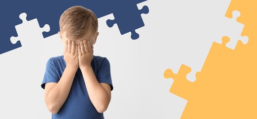 Sad little boy with autistic disorder on color background