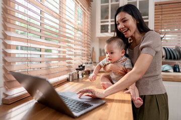 Asian single mother lovingly cares for and raises her baby boy in house. 