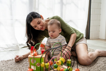 Obraz premium Asian single mother lovingly cares for and raises her baby boy at home.