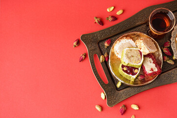 Tray with tasty Turkish delight on red background