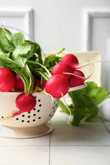 Colander with fresh radish on table