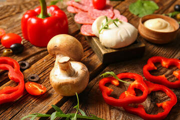 Different ingredients for preparing pizza on wooden background
