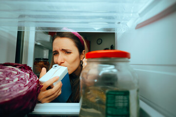 Woman Smells Milk Carton and Sees It Is Spoiled. Person checking diary product if it began smelling...