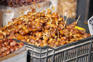 Fresh dates displayed at a market stall in a sunny outdoor setting