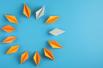 Obraz premium Colorful Origami Paper Boats Arranged in a Circular Formation on a Blue Background