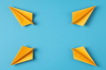 Four Yellow Paper Airplanes Arranged Symmetrically on Bright Blue Background