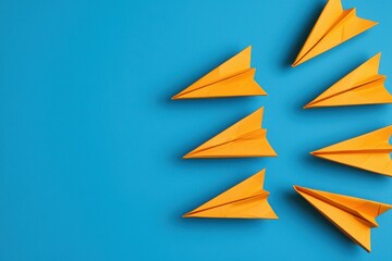 Creative Arrangement of Orange Paper Airplanes on a Bright Blue Background
