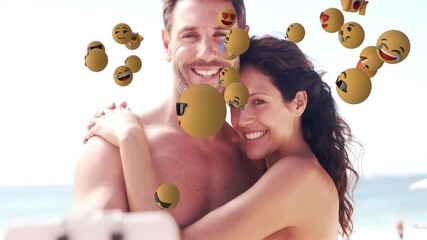Smiling couple embracing at beach with floating emoji animations around them