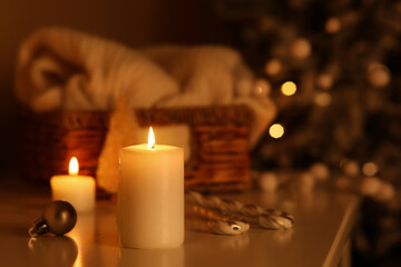 Burning candles and beautiful Christmas decorations on table in room