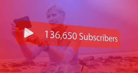Play button and subscriber count animation over person taking selfie on beach - Powered by Adobe