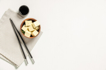 Bowl with pieces of tasty tofu cheese on white background