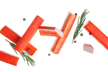 Tasty crab sticks with rosemary and peppercorns flying on white background © Pixel-Shot