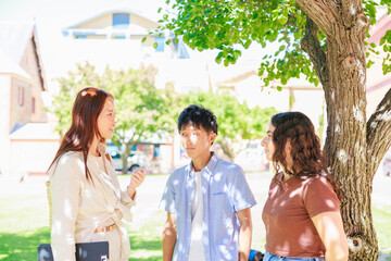公園で談笑する大学生の男女