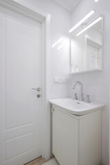 Faucet with ceramic sink and mirror in the bathroom