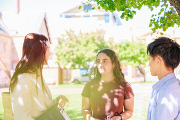 公園で談笑する大学生の男女