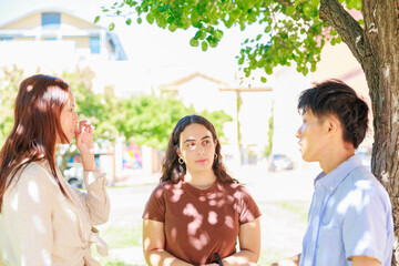 公園で談笑する大学生の男女