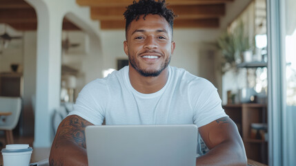 Obraz premium Confident young man smiling at laptop in bright workspace, showcasing positive attitude