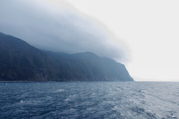 珍しく穏やかに凪いだ、夜明けの御蔵島、御蔵島港。
港湾職員が接岸作業やコンテナの積み込み作業を行っている。
東海汽船東京湾〜伊豆諸島八丈島、太平洋航路の橘丸船上 -2025
