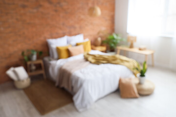 Interior of modern bedroom with brick wall, blurred view