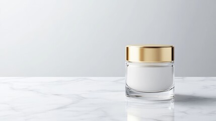 Elegant, clear glass cosmetic jar with gold cap on marble surface