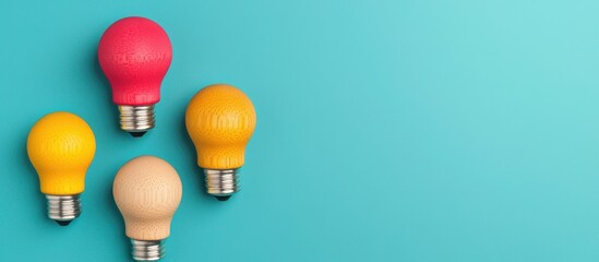 Colorful Light Bulbs in Various Sizes Against a Turquoise Background Symbolizing Creativity and Innovation