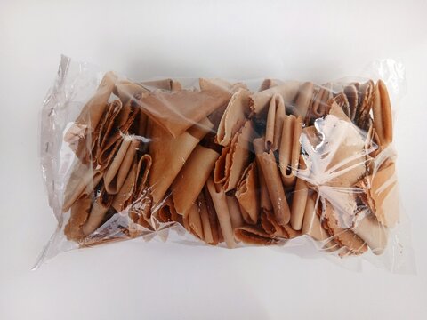 Kue semprong, Asian egg roll, sapit, sepit, kue Belanda, or kapit. Indonesian traditional wafer snack made by clasping egg batter using an iron mold.