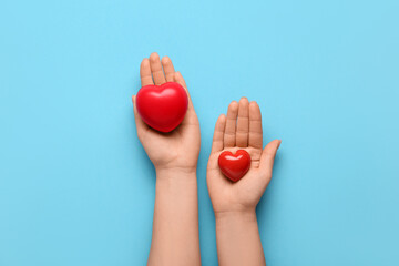 Female hands with hearts on blue background. World Health Day