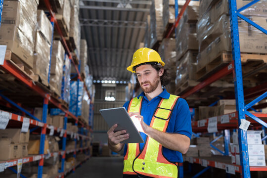 Warehouse worker, Male worker at warehouse, Storage, Check stock. Male warehouse worker checks stock inventory. Male worker holding digital tablet and checking barcodes on boxes on shelf pallet