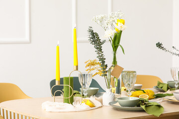 Table setting with spring flowers in light room