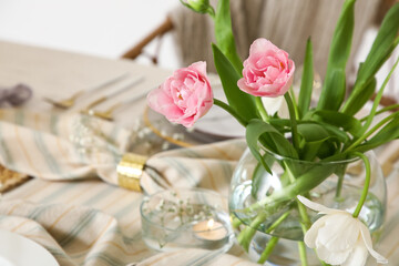 Vase with tulips on dining table in room, closeup
