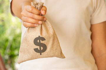 woman's hand holding a wallet and giving a bag of money, money saving and investment concept